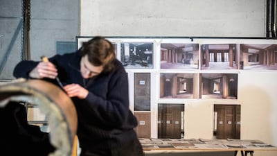 Part of the interior's international conservation team, the restorer and cabinetmaker Romain Lauchet repairs one of the room's classically-inspired Art Deco columns. Christophe Morin for The National
