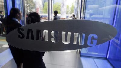 Visitors walk by the logo of Samsung Electronics in Seoul, South Korea. The company is making an $8bn foray into the connected-car market. Lee Jin-man / AP