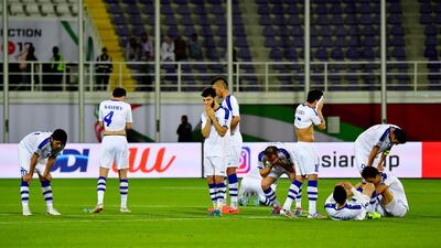 Uzbekistan players look dejected after the shoot-out defeat. AFP