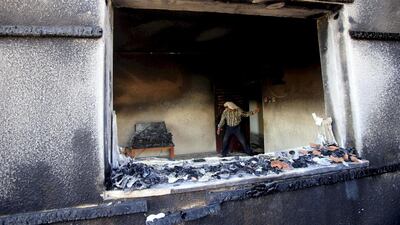 A Palestinian man inspects a house that was badly damaged in a suspected attack by Jewish extremists on two houses at Duma village near the West Bank city of Nablus on July 31. Reuters