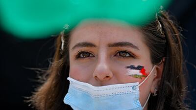 A woman, her face painted with the Palestinian flag, joins a protest in Bucharest, Romania. AP Photo