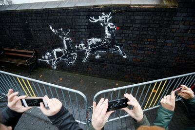 People gather around a new mural by the street artist Banksy in Birmingham. Henry Nicholls / Reuters