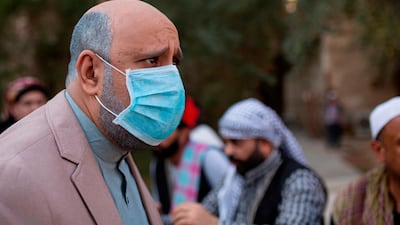 Iraqi actor Mohammad Qassem, the main character of a parody sketch video of Bab al-Hara, an adaptation of an iconic long-running Syrian television drama, wears a face mask while acting on set in Iraq's southern port city of Basra on April 22, 2020. AFP / Hussein Faleh