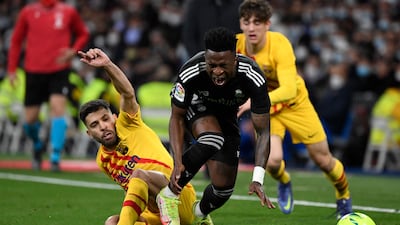 Real Madrid forward Vinicius Junior is fouled by Barcelona defender Jordi Alba. AFP