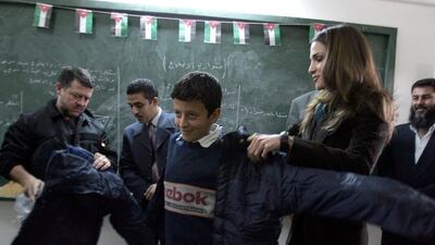 King Abdullah and Queen Rania visit a school in Amman in October 2005. AFP