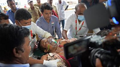 A man is shifted on a stretcher upon arriving in an ambulance at the civil hospital in Ahmedabad on July 26, 2022, after suffering health problems due to consuming bootleg liquor. (Photo by Sam PANTHAKY / AFP)