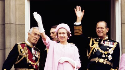 Queen Elizabeth II and the Duke of Edinburgh wave from the balcony of Buckingham Palace after her silver jubilee procession in 1977. PA