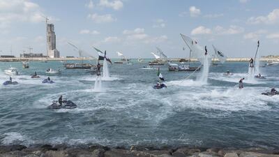 Spectators participate in a flag raising ceremony in celebration of the UAE’s 43rd National Day at the Breakwater in Abu Dhabi. Rashed Al Mansouri / Crown Prince Court - Abu Dhabi