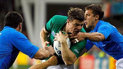 Brian O'Driscoll, centre, is stopped by three Italian players during Ireland's 36-6 win to top Pool C and pair them with Wales in the quater-finals of the Rugby World Cup.
