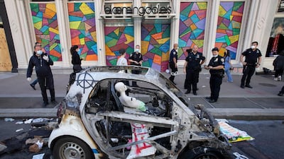 Police officers stop to look at a burned out police car, Monday, June 1, 2020, in the SoHo neighbourhood of New York. AP