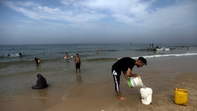 Palestinians gather at the beach in Deir Al Balah, central Gaza, to bathe and clean their clothes. AP