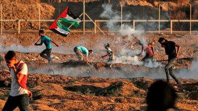 Protesters react to tear gas fired by Israeli forces during clashes in Gaza City. AFP