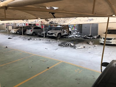 Burnt debris lies scattered across cars and a parking area at Marina Diamond 2. Nicholas Webster / The National