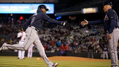 Atlanta Braves' Justin Upton is greeted by third base coach Brian Snitker after his home run against Colorado Rockies.