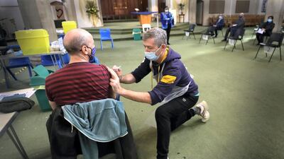 A man receives a Covid-19 vaccination in Ealing, west London, in the UK. England is speeding up the vaccination of over-50s. AP