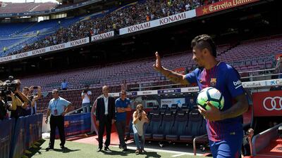 Barcelona's new Brazilian football player Paulinho waves as he enters the pitch at Camp Nou. Lluis Gene / AFP