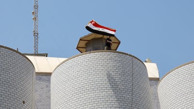 A supporter of Mr Al Sadr waves a flag during the protest at the parliament building. Reuters