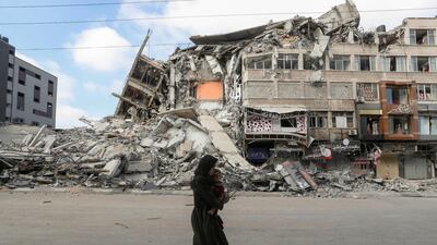 A Palestinian woman carries her son as she flees her home during Israeli strikes. Reuters