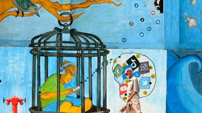 A man wearing a face mask as a preventive measure against the Covid-19 coronavirus walks past a mural in Colombo. AFP