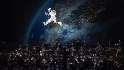 A performer playing an astronaut hangs in front of a projection of an orchestra at an event marking the 70th anniversary of the German state of Hesse at the Staatstheater in Wiesbaden, Germany, on December 1, 2016. Arne Dedert / EPA