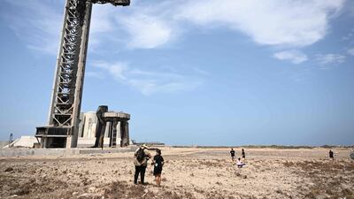 People walk through the debris after the SpaceX Starship's successful test lift-off from Boca Chica, Texas. The rocket blew up after a short flight. AFP