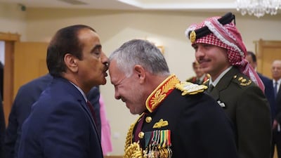 A handout picture released by the Jordanian Royal Palace shows a wellwisher kissing the forehead of Jordan's King Abdullah II as his son Crown Prince Hussein looks on, at the opening of the fourth ordinary parliamentary session in the capital Amman. AFP