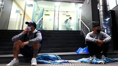 Fans of Diego Maradona wearing face masks wait outside of Clínica Olivos. Getty Images