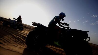 Quad bikers in the UAE are encouraged to wear appropriate safety gear and helmets at all times when riding. Ali Haider / EPA