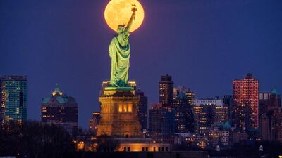 The rising full moon crosses behind the Statue of Liberty, Monday evening, March 9, 2020, in New York City. AP Photo