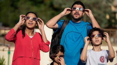 Members of a family use special protective glasses to observe an annular partial solar eclipse in Cairo, Egypt. EPA