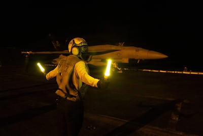 A US sailor signals an F/A-18E Super Hornet on the flight deck of Nimitz-class aircraft carrier USS George HW Bush in July. AFP