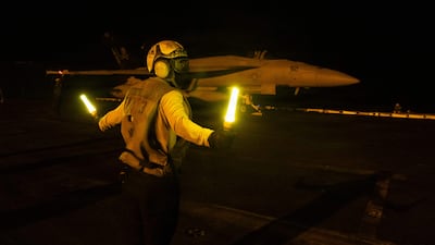 A US sailor signaling an F/A-18E Super Hornet on the flight deck of the USS George HW Bush aircraft carrier on July 21. AFP