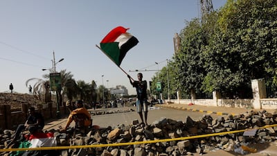 A Sudanese protester waves a national flag on a barricade on a road leading to the defense ministry compound in Khartoum, Sudan, April 30, 2019. Reuters