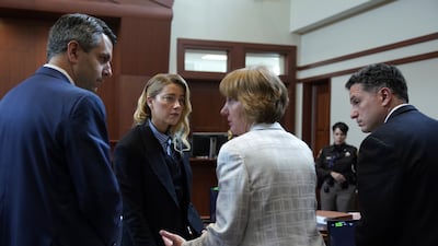Actor Amber Heard convenes with her legal team at lunch break before taking the stand. EPA