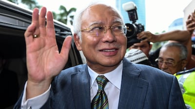Malaysia's former prime minister Najib Razak waves as he leaves court after pleading not guilty in a multi-billion-dollar financial case. AFP