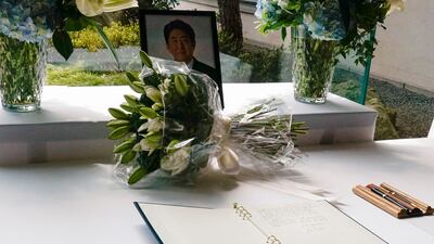 Mr Biden's bouquet of lilies sits opposite the book of condolence. AP