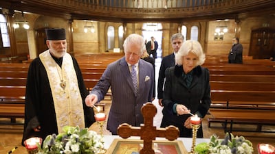 The Prince of Wales and the Duchess of Cornwall light candles during a visit to the Ukrainian Catholic Cathedral of the Holy Family, in London, on Wednesday, March 2, 2022. PA