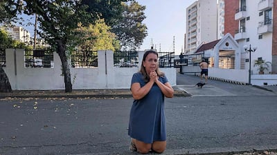 A woman prays on a street in Cali. AFP