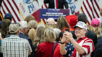A person takes a photo as former US President and 2024 Presidential hopeful Donald Trump speaks in Iowa. AFP