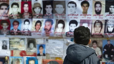 A child looks at the portraits of some of the 1,200 victims of the 1996 Abu Salim prison massacre by the regime in the Libyan rebel stronghold of Benghazi on April 2, 2011. Odd Andersen / AFP