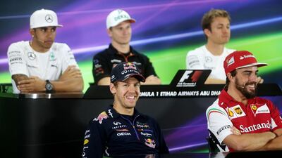 Red Bull driver Sebastian Vettel, bottom left, smiles during Thursday's press conference ahead of the Abu Dhabi Grand Prix, while Ferrari driver Fernando Alonso, bottom right, Mercedes driver Lewis Hamilton, back left, Force India driver Nico Hulkenberg, centre and Mercedes driver Nico Rosberg look on. Christopher Pike / The National