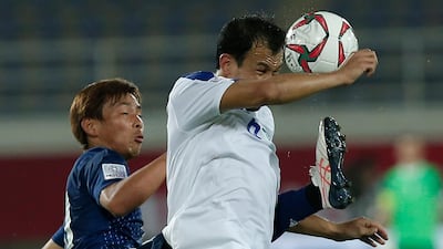 Uzbekistan's Davron Khashimov, right, heads the ball against Japan's Shoya Nakajima. AP Photo