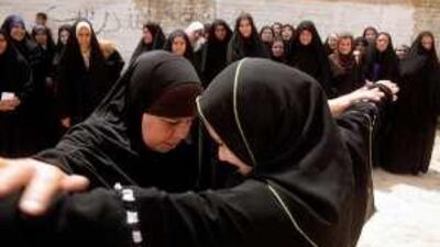 An Iraqi policewoman, left, demonstrates proper search techniques as women begin training to join the Daughters of Iraq last year.