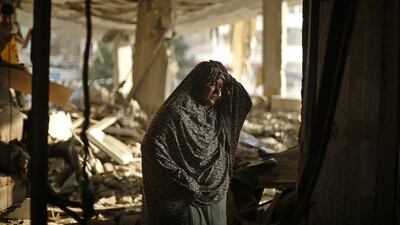 A Palestinian woman in the ruins of her Gaza City house after an Israeli air strike. Photo: Reuters / Mohammed Salem