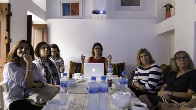 Art historian Rose Balston, centre, tells an audience the story of oriental carpets in renaissance paintings, at XVA Gallery in Dubai. Christopher Pike / The National