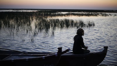 An Iraqi man sits on a boat at the Chebayesh marsh in Dhi Qar province, Iraq. Reuters