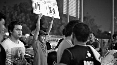 A member of the Jafiliyah Basketball Committee holds up a board with the final score.