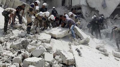 Rescue services, rebel fighters and civilians search for survivors at a site hit by what activists said was a barrel bomb dropped by the Syrian air force in Al Qarlaq neighbourhood of Aleppo. Jalal Al Mamo / Reuters / May 29, 2014