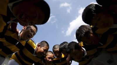 Members of Katsushika Rugby School huddle at the end of a one-day skills camp in Tokyo. Yuya Shino / Reuters