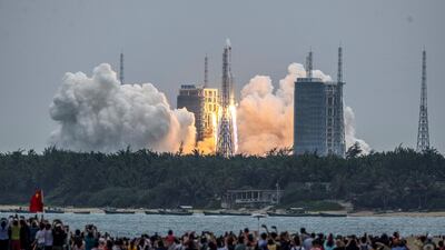 People watch a Long March 5B rocket, carrying China's Tianhe space station core module, as it lifts off from the Wenchang Space Launch Center in southern China's Hainan province on April 29, 2021. (Photo by AFP) / China OUT